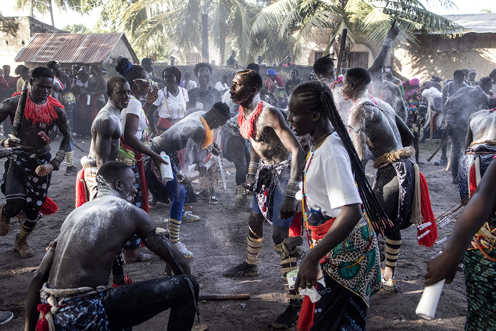 Young men perform to show their strength as girls cheer during a ceremony marking the end of the yearly initiation process for young men.