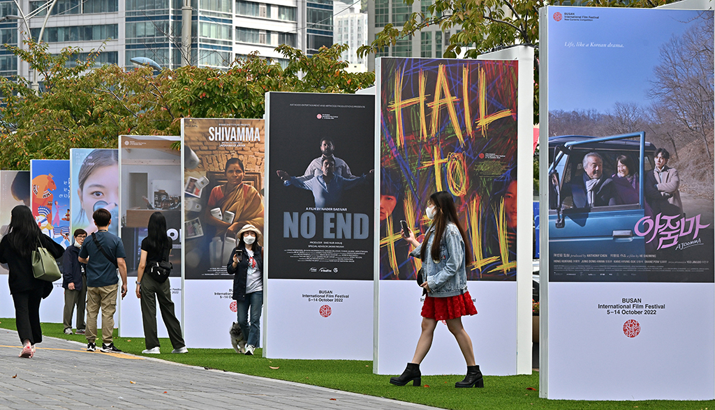 People walk past cinema posters for the 27th Busan International Film Festival (BIFF) at the Busan Cinema Center.