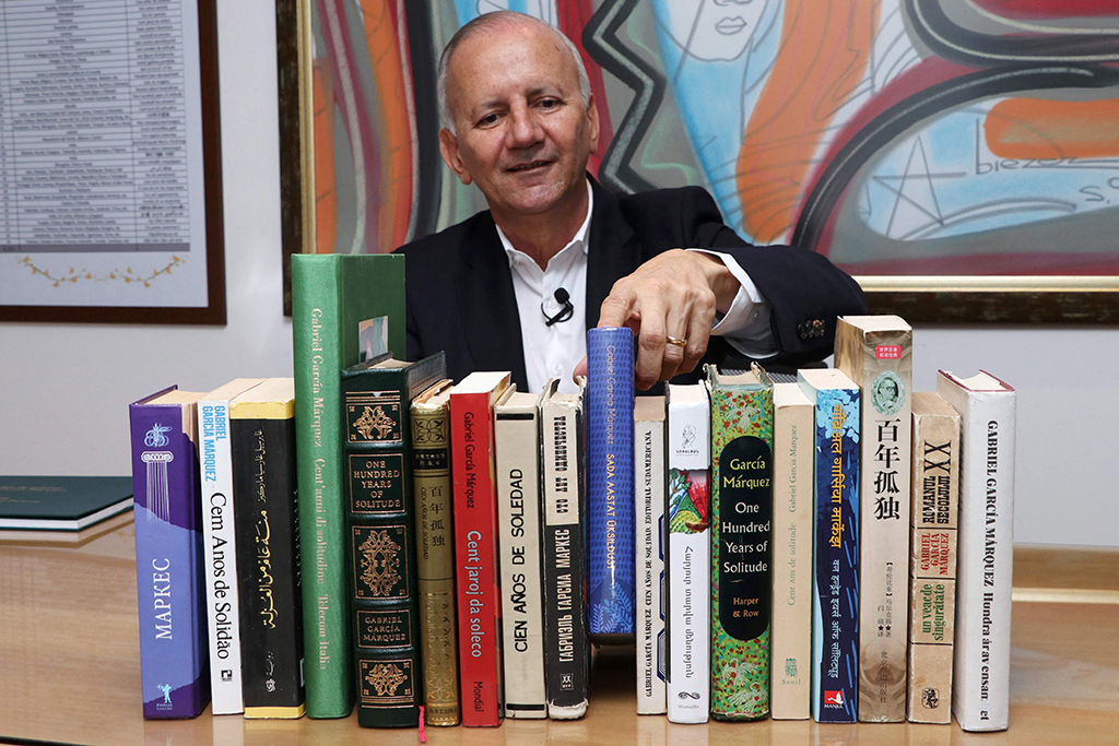 Jorge Salazar poses with several editions