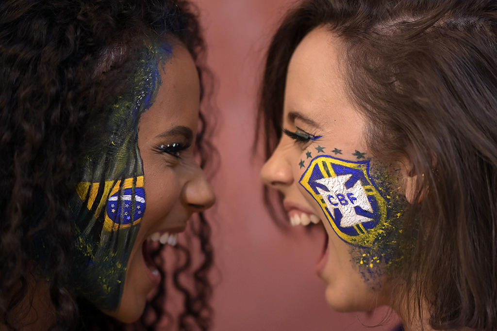 Makeup artist Natalia Bastos (right), who creates themed makeup for the FIFA World Cup Qatar 2022, poses in her studio with client Milene Cristina in Ibirite, metropolitan region of Belo Horizonte, Brazil.