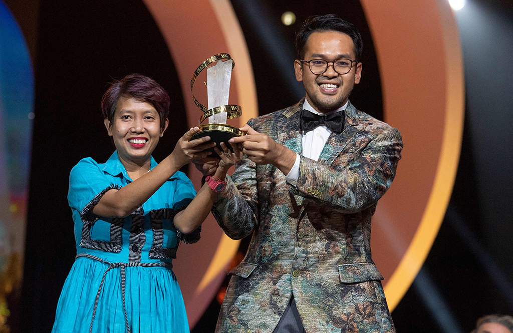 Indonesian producer Yulia Evina carries with Indonisian film maker and actor Makbul Mubarak his trophy for best actor for his role in the movie 