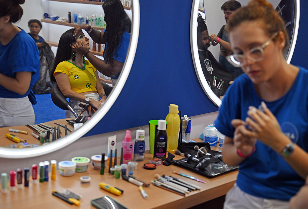 A fan of Brazil has her makeup done at a booth after watching the live broadcast of the Qatar 2022 World Cup.