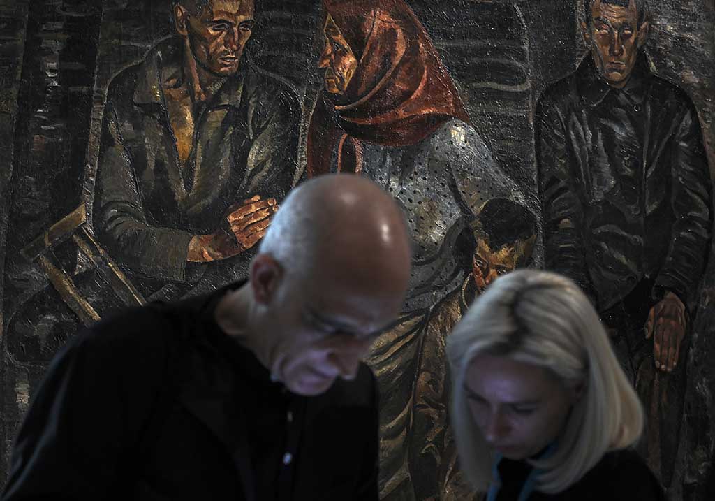 Marina Drogotiu (right), chief curator of the National Museum of Ukraine, stands near a painting during the press preview of 'In the Eye of the Storm' an exhibition on Ukrainian avant-garde art.