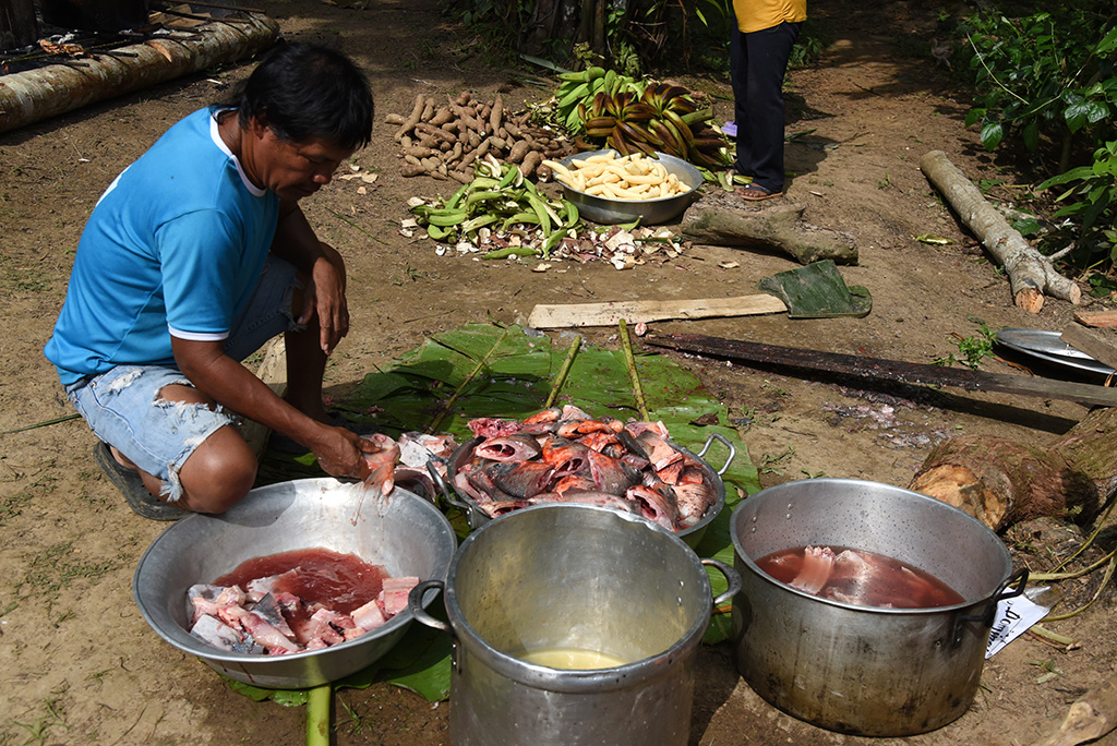 A Tikuna indigenous man prepares a community lunch in San Martin de Amacayacu, Colombia.
