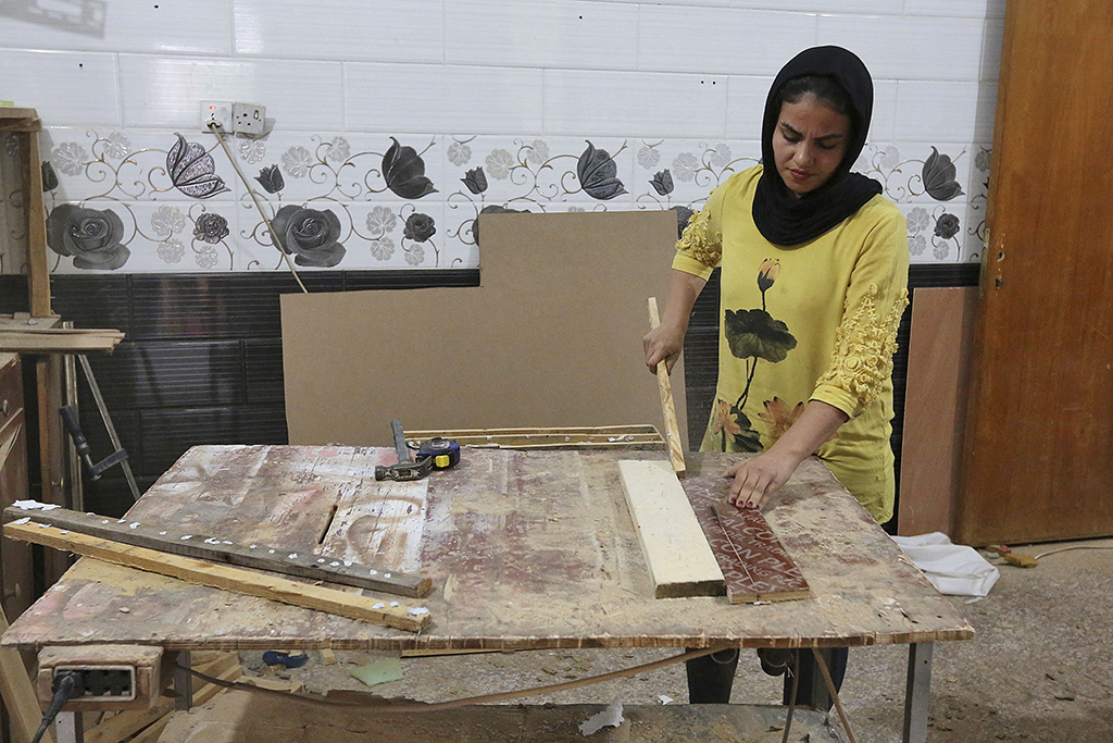 Iraqi carpenter Nour Al-Janabi works at her home furniture workshop. 