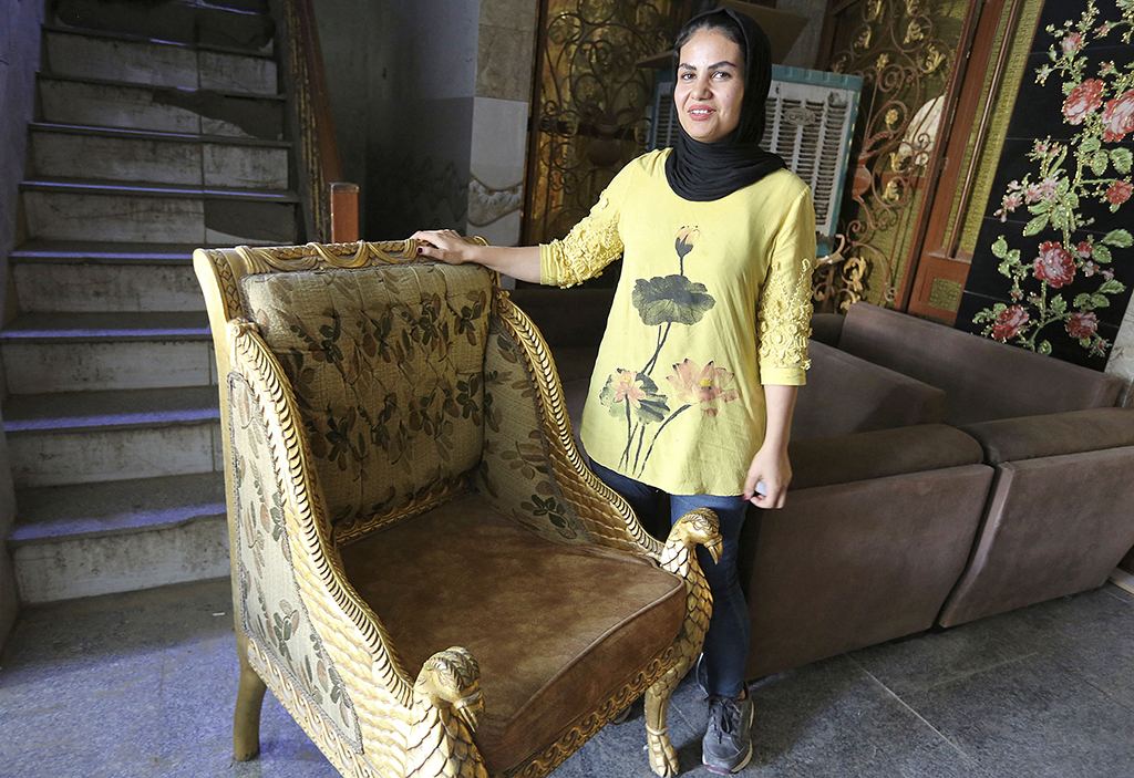 Iraqi carpenter Nour Al-Janabi displays a piece at her home furniture workshop.