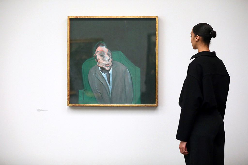 A gallery assistant poses next to 