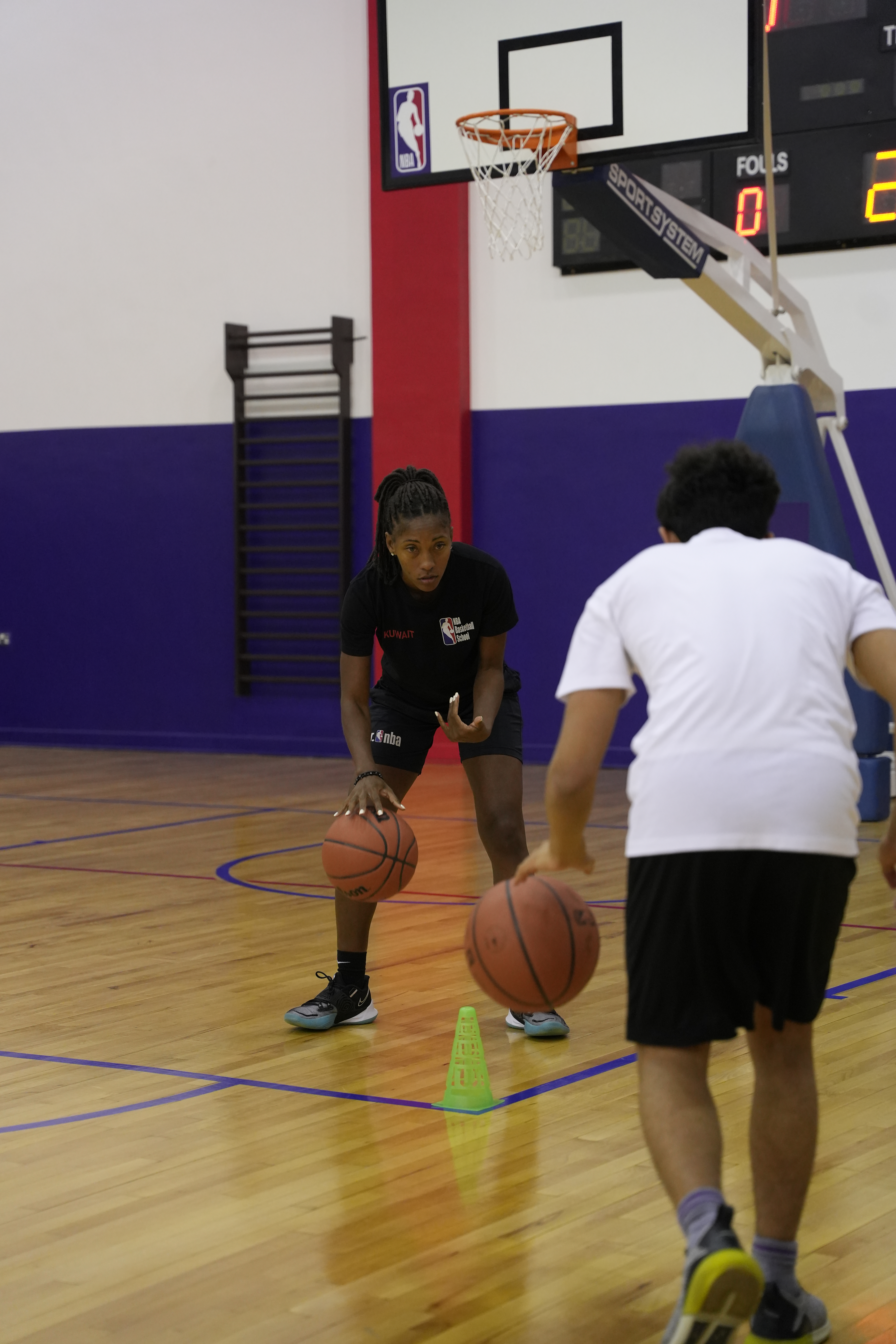Coach Jade Leitao teaches a student how to dribble.