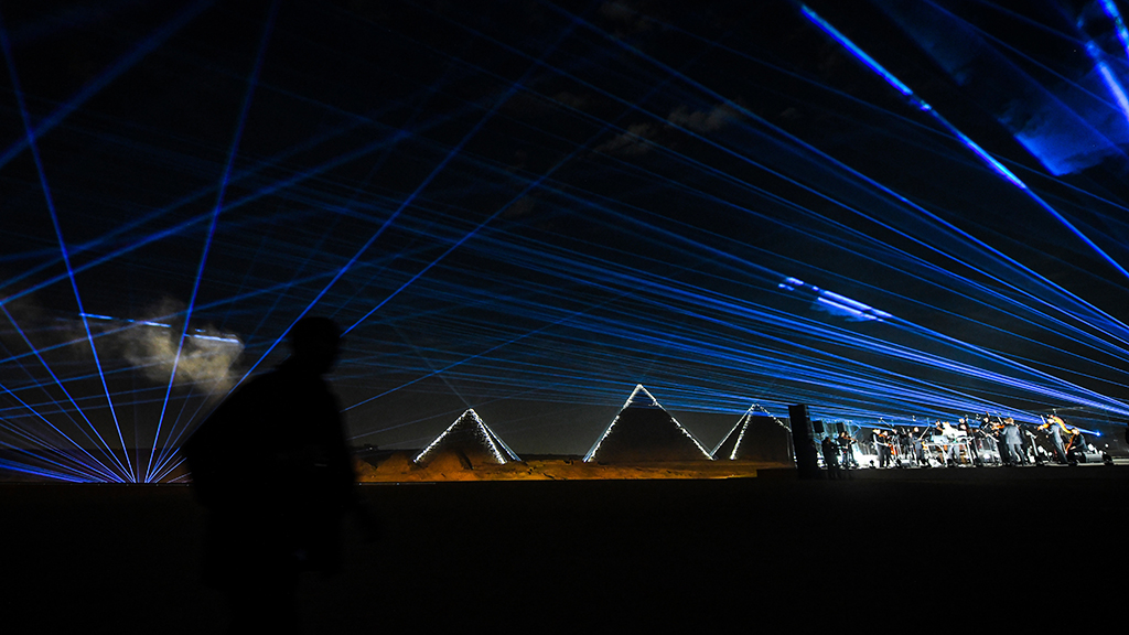 (From left to right) The Pyramid of Menkaure (Menkheres), the Pyramid of Khafre (Chephren), and the Great Pyramid of Khufu (Cheops) are illuminated as a band plays at the Christian Dior fashion show at the Giza Pyramids Necropolis on the outskirts of the twin city of Egypt's capital.