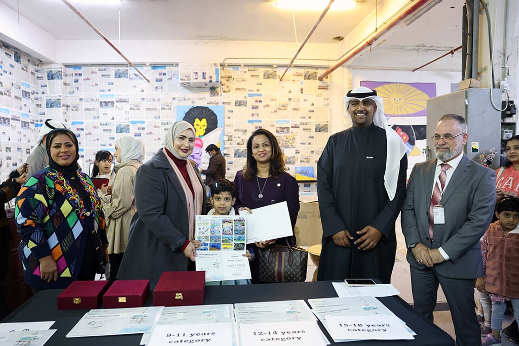 Hamad Al-Musaibeeh, Corporate Relations Department Manager at Zain (right), Amal Nasser Al-Jufaira, one of the jury members (left), present an award to the fifth winnerAnvitha Sumesh (center) in the 6-8 category.