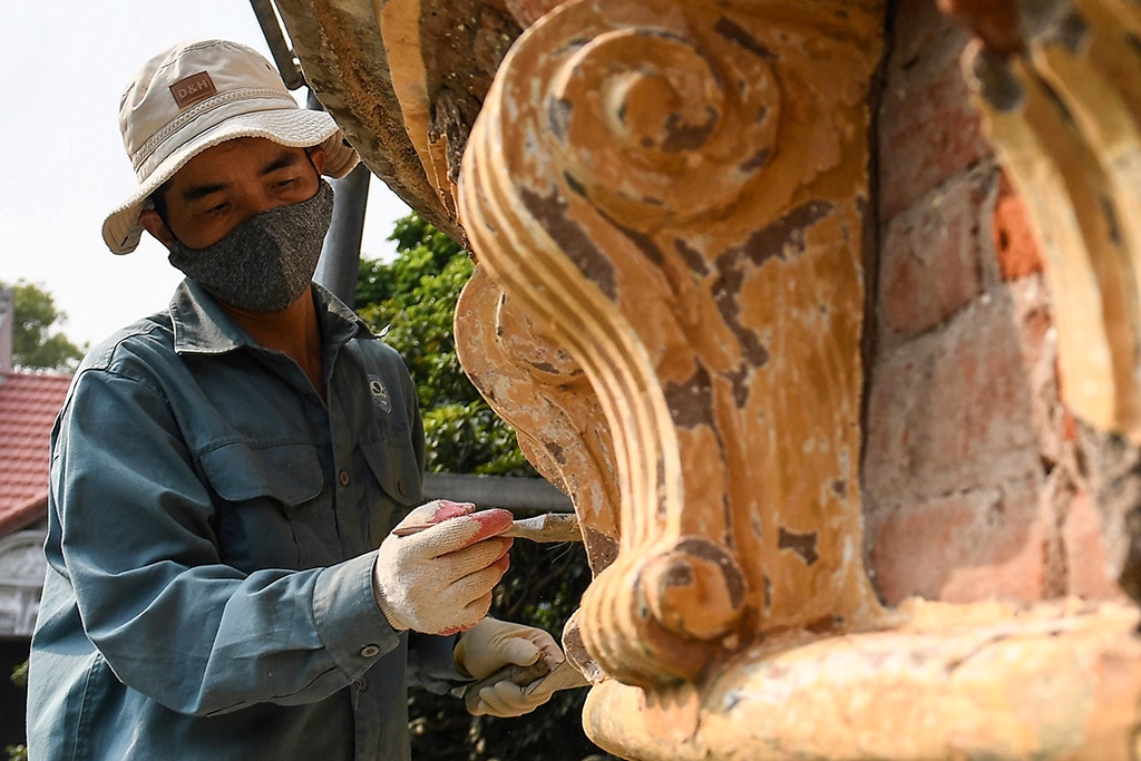 This photo shows a construction worker remodeling an old villa in Hanoi. 