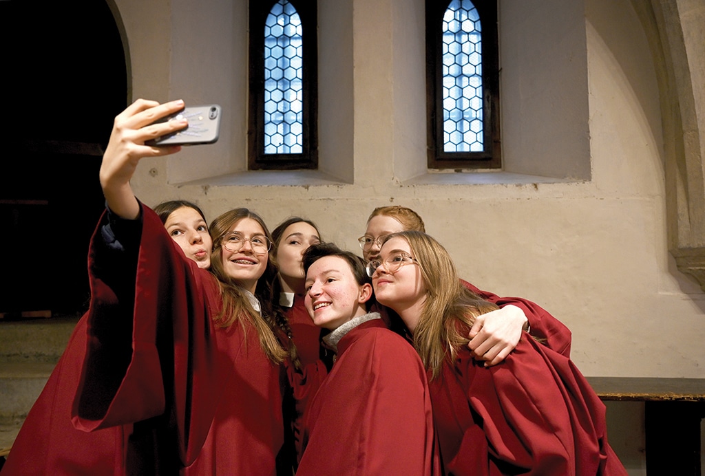 Members of the Regensburger Domspatzen girls' choir take a group selfie prior to their first appearance during a service at the Regensburg Cathedral.