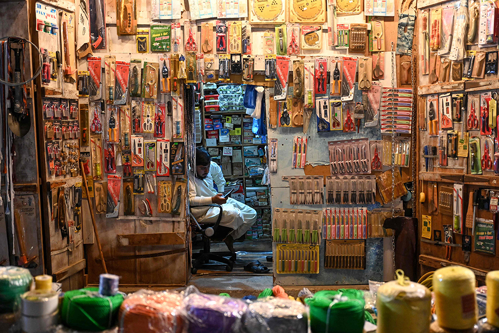 An ironmonger vendor sit inside his shop in Souq Waqif marketplace in Doha. 