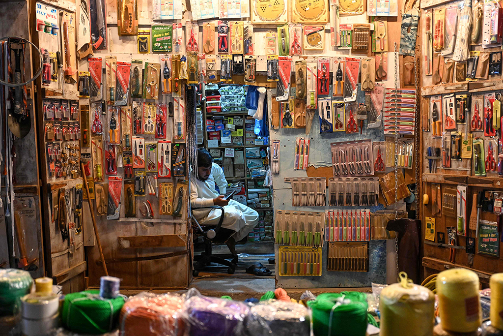 An ironmonger vendor sit inside his shop in Souq Waqif marketplace in Doha.