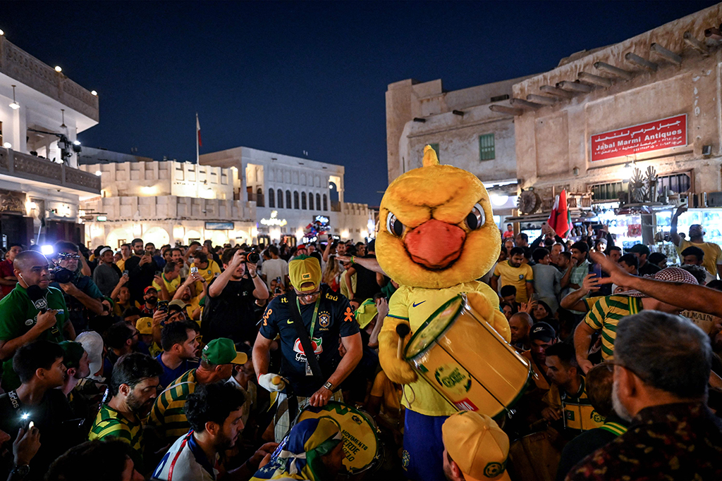 A Brazil's supporter wearing a bird costume celebrates at the Souq Waqif marketplace.