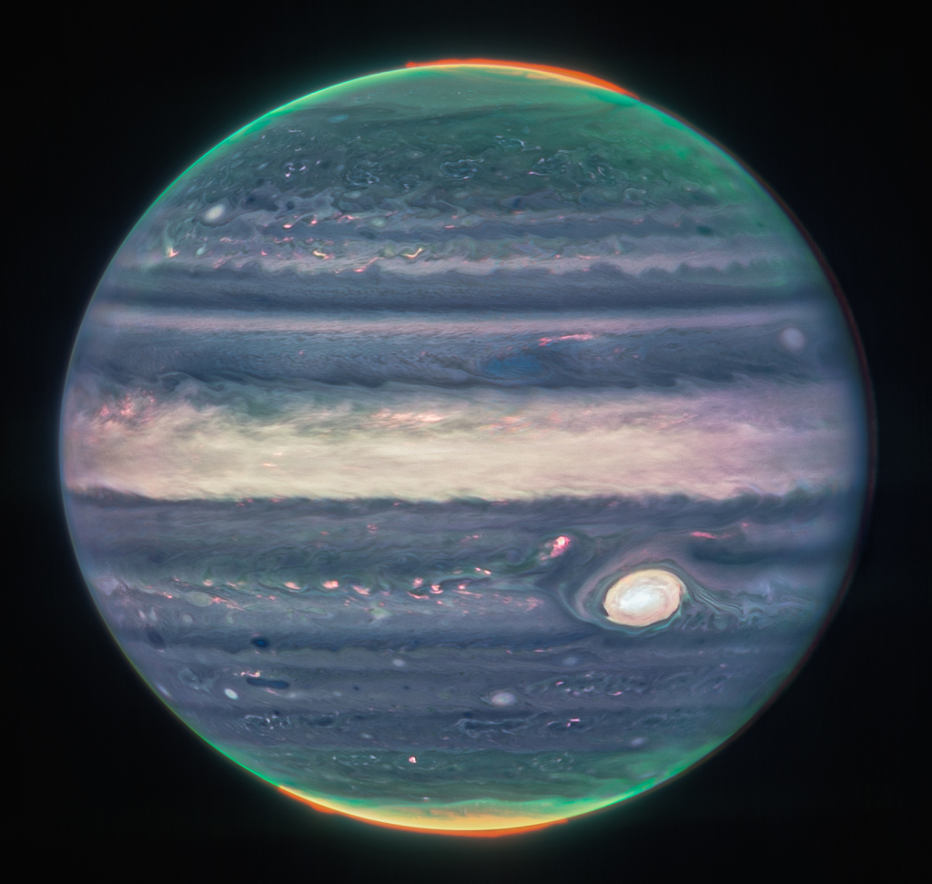This handout image taken and obtained from NASA and taken by the James Webb Space Telescope, shows Jupiter's weather patterns, tiny moons, altitude levels, cloud covers and auroras at the northern and southern poles. 