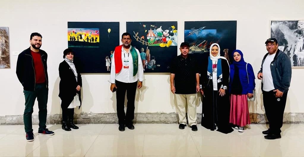 Arab artists posing near Kuwaiti artist Abdullah Al-Jiran’s artworks.