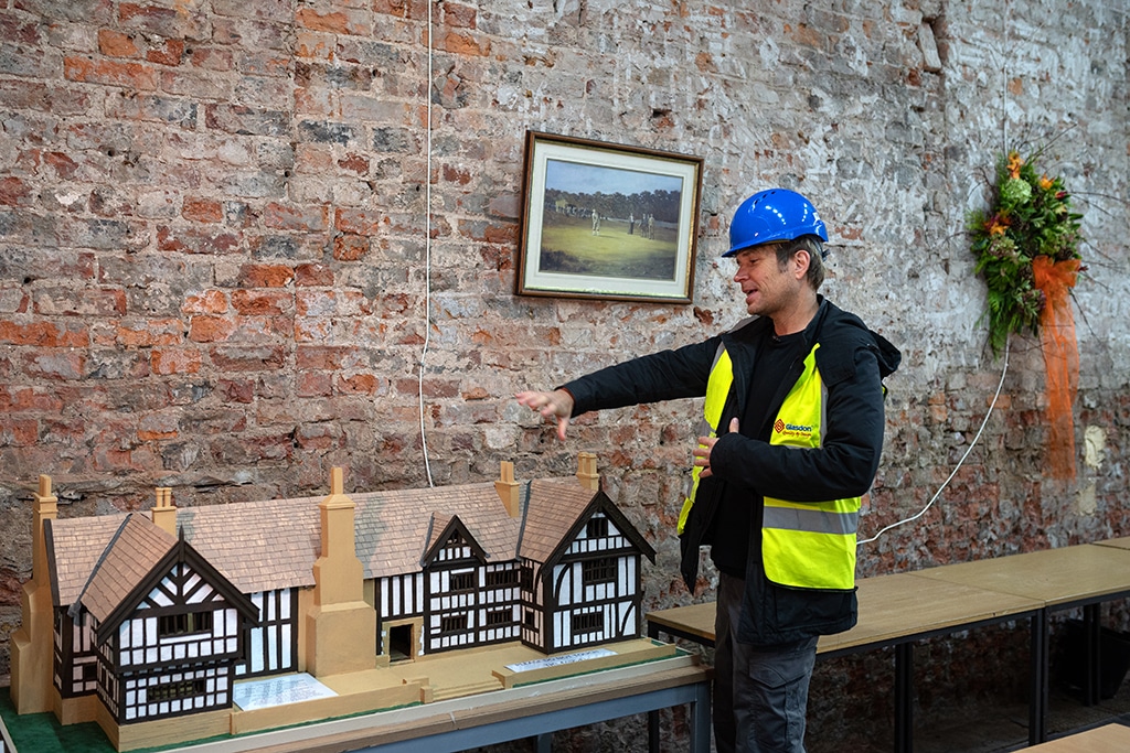 Hopwood DePree inspects a model of the original layout of Hopwood Hall inside one of the rooms of the Hall, his family's ancestral home.