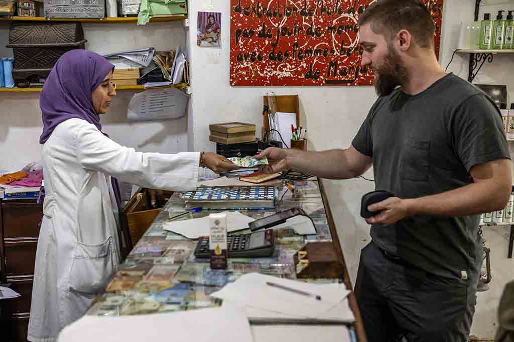 A tourist buys a bottle of argan oil at a shop near Morocco's western Atlantic coastal city of Essaouira.