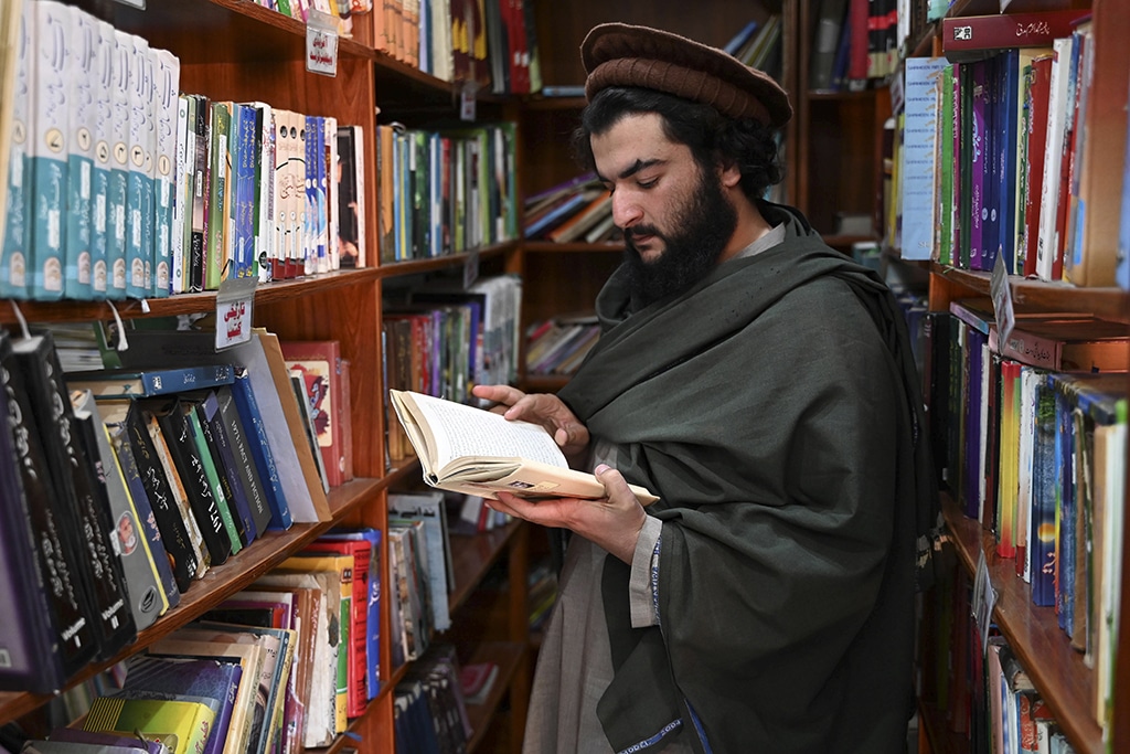 An arms dealer Hakimullah Afridi reads a book at the Darra Adam Khel library. 
