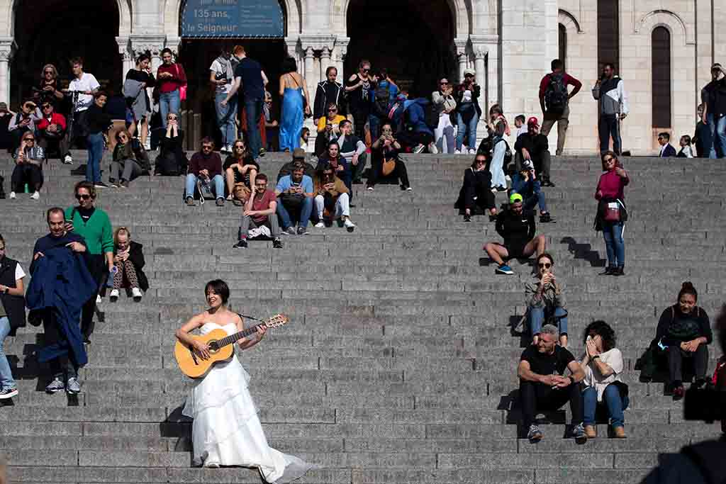 Eli Jadelot, performs in a wedding dress in front of the Sacre Coeur in Paris.