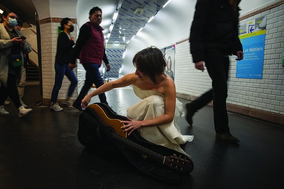 Eli Jadelot, in a wedding dress, performs at the subway station “Arts et Metiers” in Paris.