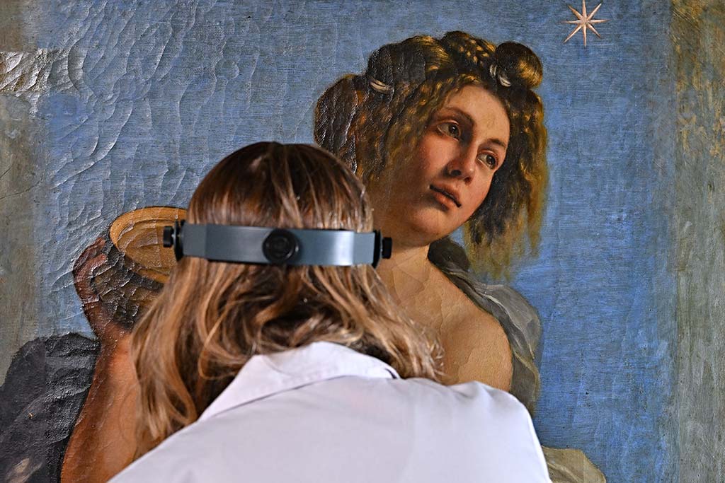 US conservator Elizabeth Wicks, works on a painting by Artemisia Gentileschi's painting 'Allegoria dell'Inclinazione' in the Casa Buonarroti Museum.