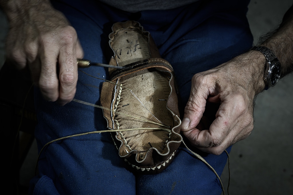 An employee of French shoemaker Weston sews a shoe at the company's factory in Limoges.