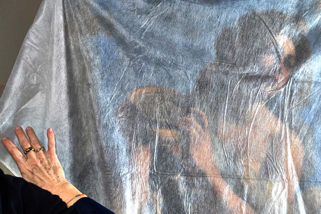 US conservator Elizabeth Wicks, removes the protective cloth covering a painting by Artemisia Gentileschi's painting 'Allegoria dell'Inclinazione' in the Casa Buonarroti Museum.