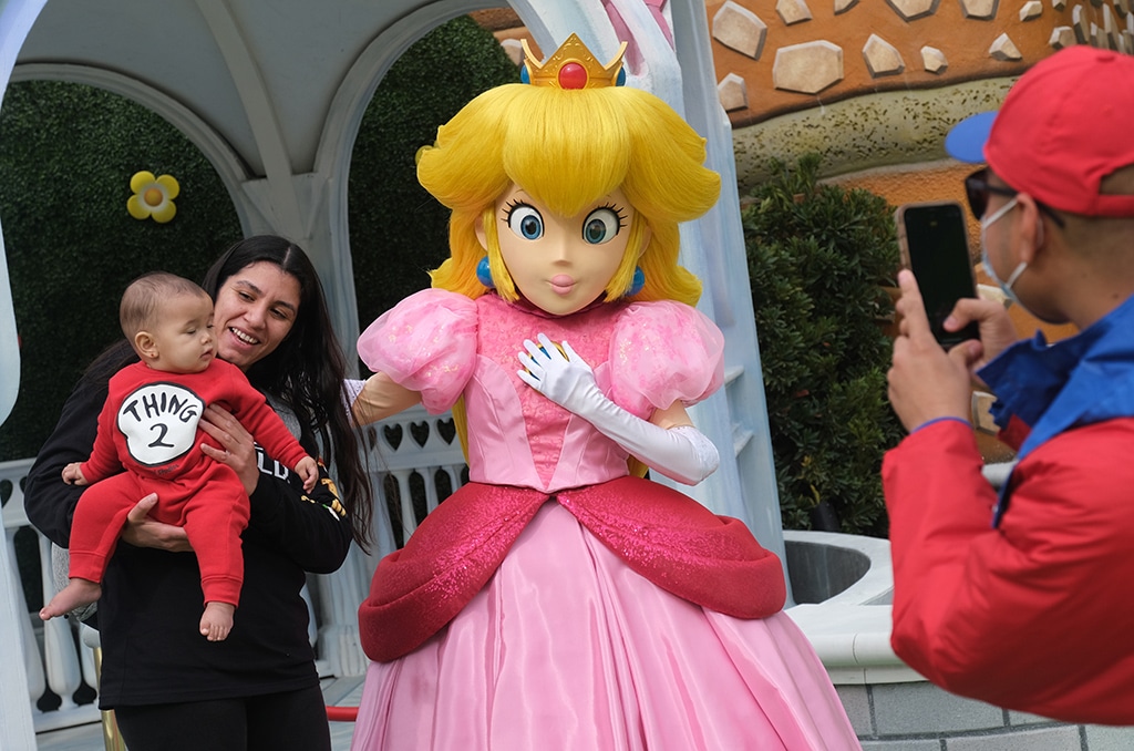Guests take pictures with Princess Peach during a preview of Super Nintendo World at Universal Studios.