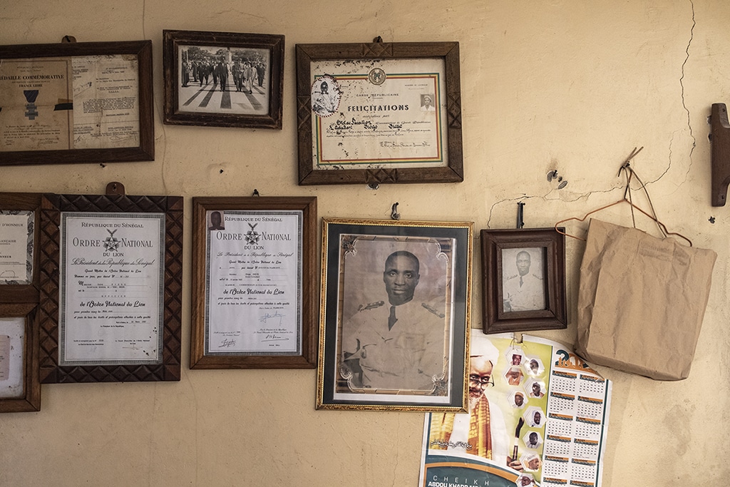 This photograph shows a portrait and certificates of Diogo Dieye 103, a former Senegalese tirailleur who fought for the French during World War II, in Lebanon and in Libreville, hanging on the wall in his room. 