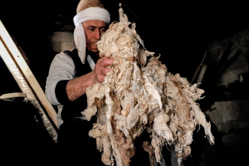 Hatmaker Youssef Akiki holds handfuls of sheep wool before shaping it into a traditional 
