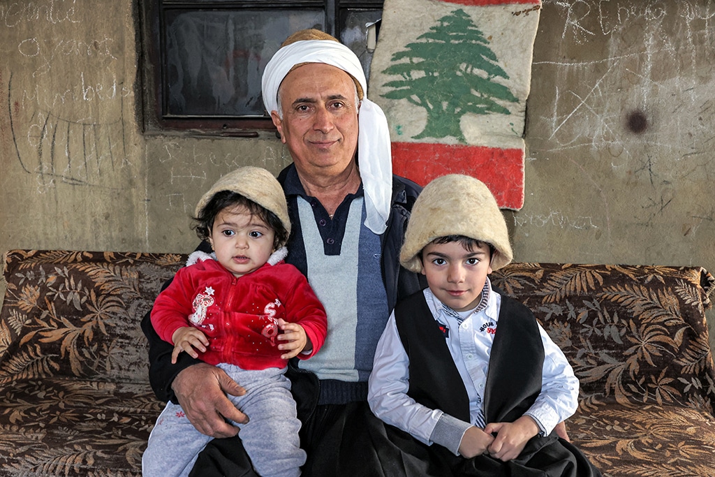 Hatmaker Youssef Akiki poses for a picture with his daughter and nephew as they wear traditional 