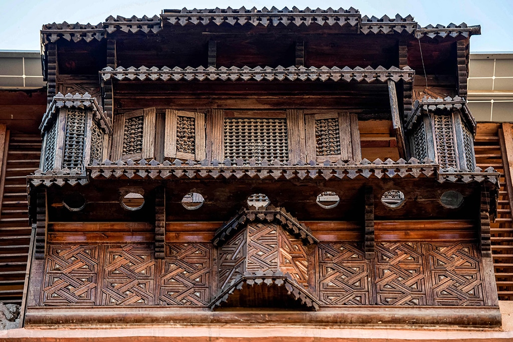 This picture shows a view of a mashrabiya, a balcony enclosed with carved wood latticework in traditional Islamic architecture, at the historical 