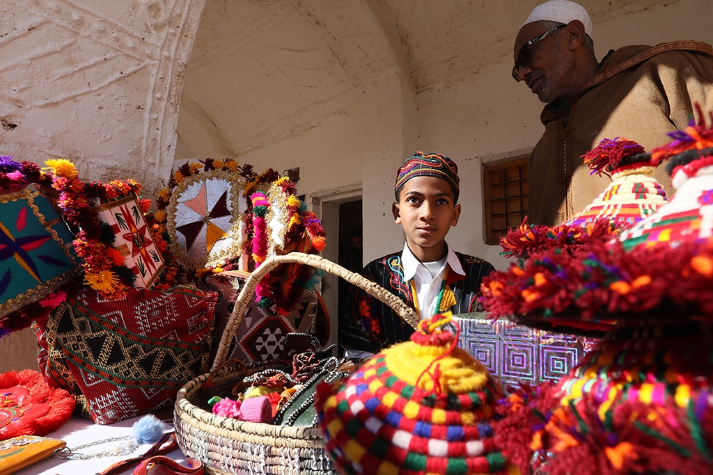 A young boy in colorful dress poses for a picture during the opening of the Ghadames festival.