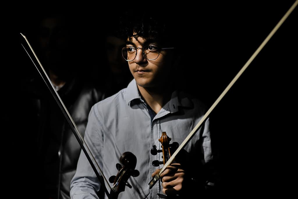 A music student of the National Institute of Music of Afghanistan (Anim) hold his instrument at the backstage prior to a concert.