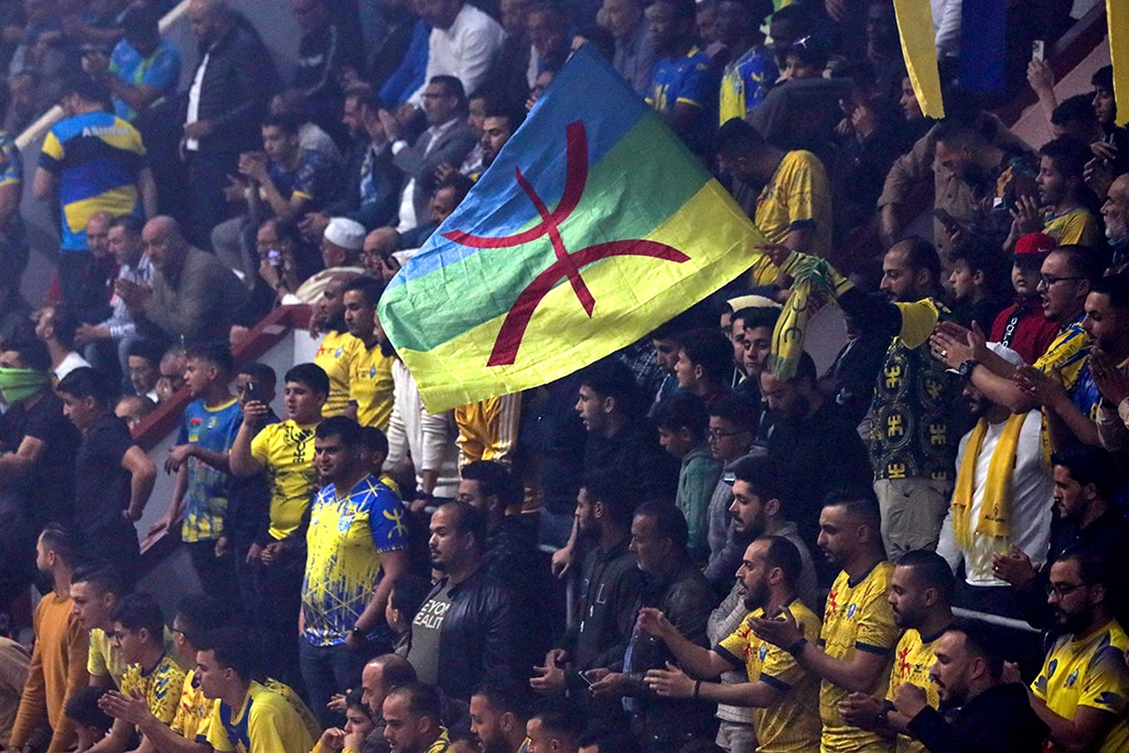 In this picture a fan holds a flag with the logo of the Tamazight language during a handball match between Al-Jazira Zuwara and Al-Ahly Tripoli, in Zuwara, a majority-Berber community near the border with Tunisia.