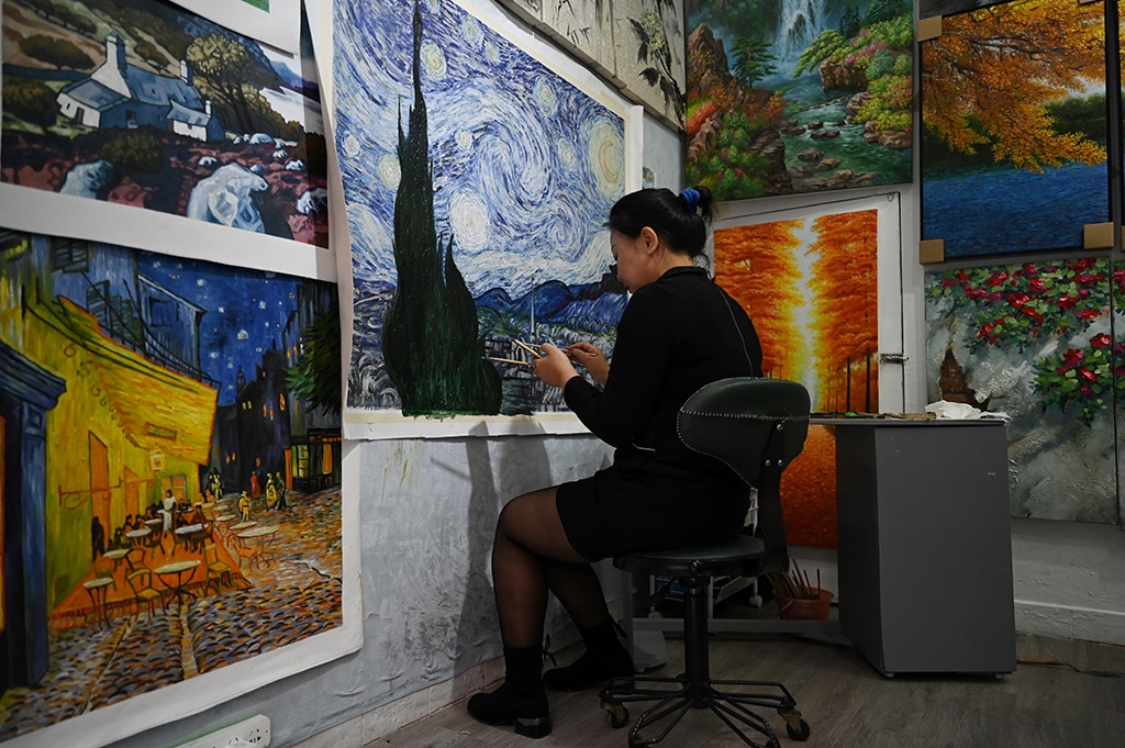 This picture shows an artist painting a Vincent Van Gogh replica in a studio at Dafen village.