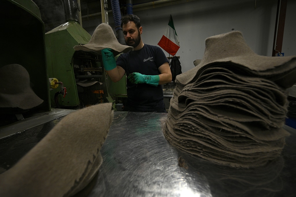 An employee works at the Borsalino hat company's factory in Alessandria on March 28, 2023. - AFP