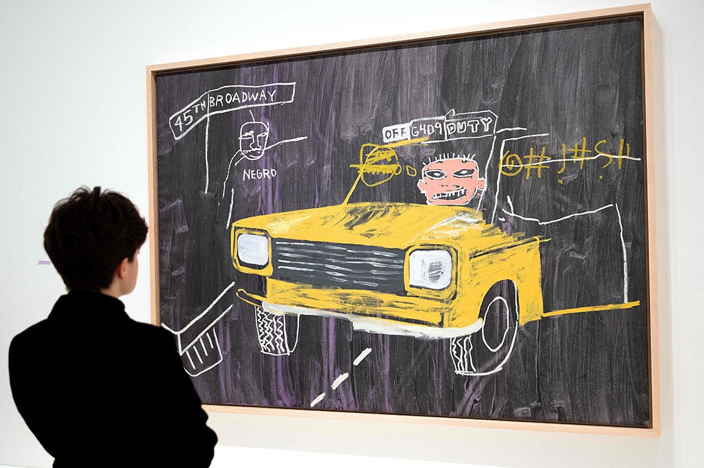 A visitor looks at “Taxi, 45th/Broadway”, an acrylic and oilstick, synthetic polymer and silkscreen ink painting.