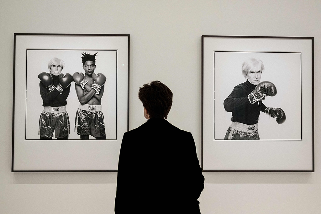 A visitor looks at black and white photographs made in 1985 by US Michael Halsband, depicting portraits of US<br>artist Jean-Michel Basquiat and US artist, Andy Warhol.