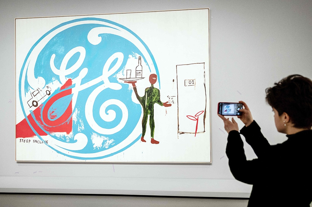 A visitor takes a photograph of “General Electric with Waiter”, an acrylic painting.