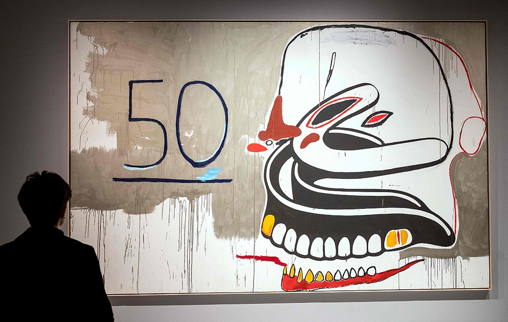 A visitor looks at “Untitled (50 Dentures)”, an acrylic and silkscreen ink painting.