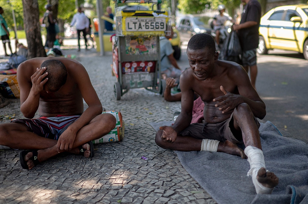 A homeless man prays before getting a meal donated by Brazilian chef Carlos Alberto da Silva, known as Nego Breu, and his team at the Lapa neighborhood in Rio de Janeiro.