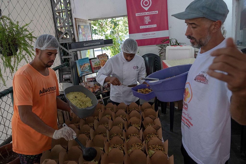 Volunteers prepare meals to be delivered to the homeless population of the city center of Rio de Janeiro at the restaurant Chapeu do Chef, at the Chapeu Mangueira favela in Rio de Janeiro.
