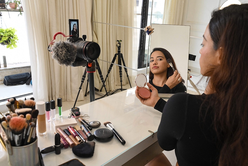 Social media beauty and lifestyle influencer Banerjee does her make-up while going live on her YouTube channel in Mumbai.