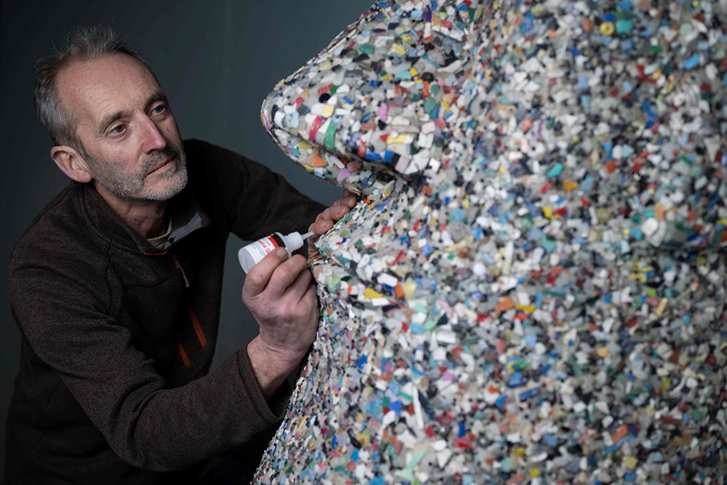 Artist and environmental activist Rob Arnold, works on a sculpture called 'A Lesson of history' that he created in 2017, inspired by the Moai heads on the Easter Island, entirely made from nurdles and other micro-plastics.