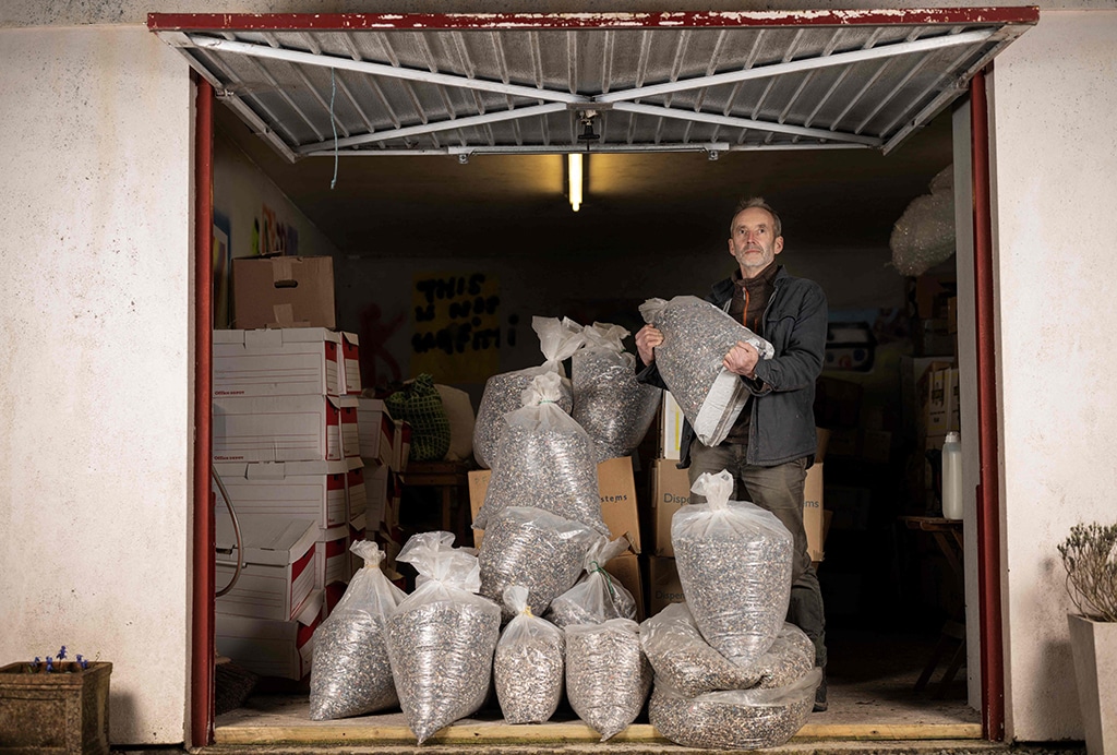 Environmental activist and artist Rob Arnold poses with his bags containing 20 millions nurdles that he collected over six years during beach cleanings outside a garage where he store them.
