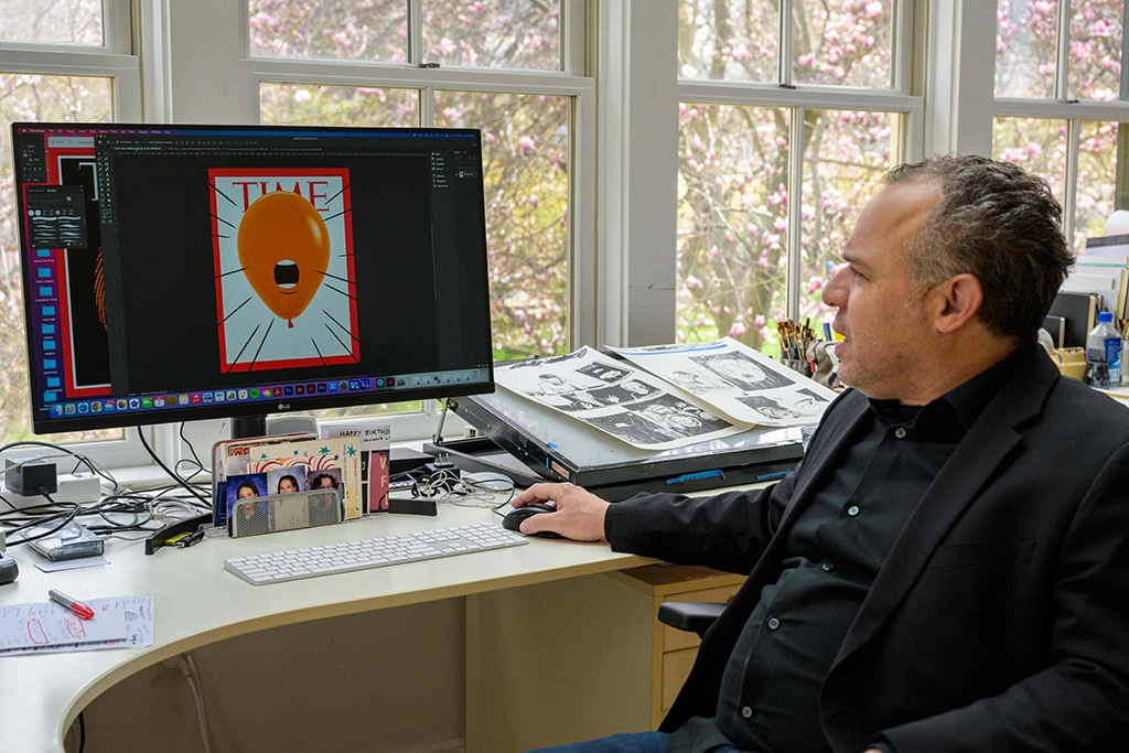 Cuban American artist and illustrator Edel Rodriguez looks at a Time cover on his computer.