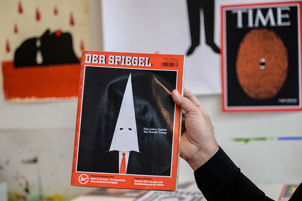 Cuban American artist and illustrator Edel Rodriguez holds up a copy of Der Spiegel in his studio.